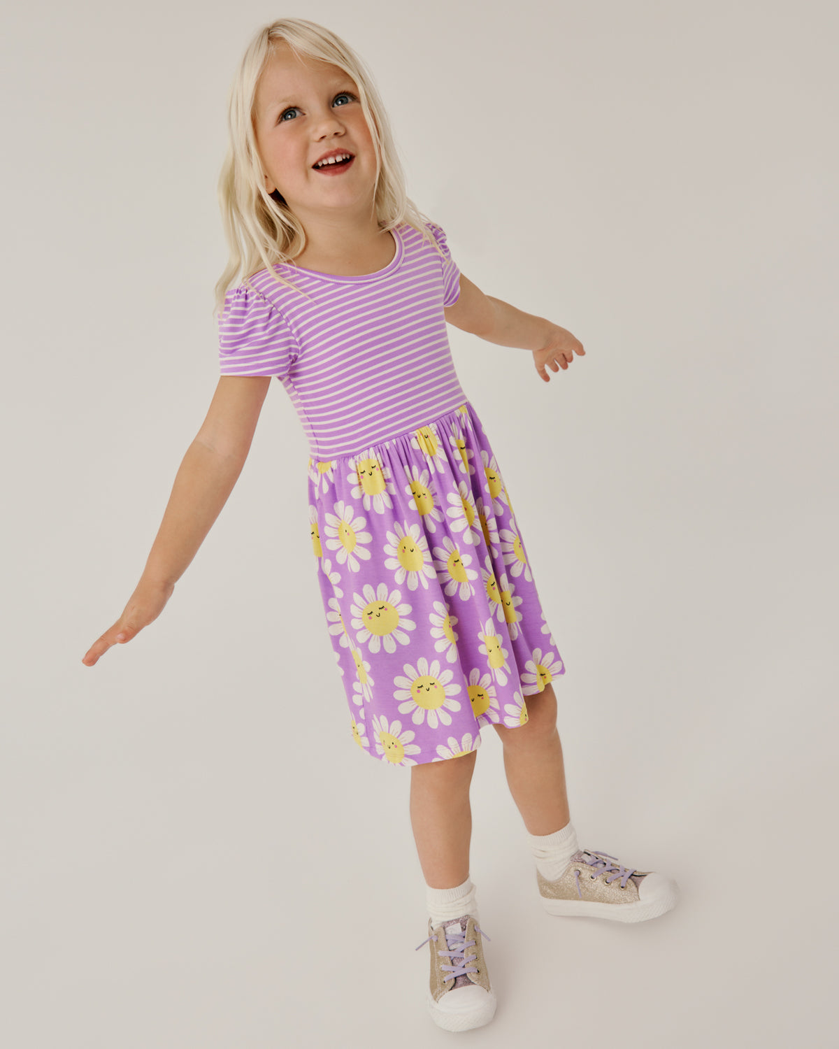 Standing girl wearing the Flower Power Skater Dress with sneakers