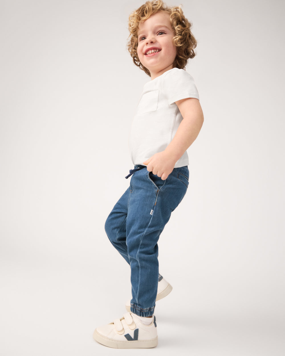 Boy wearing the Midwash Blue Denim Jogger with a white tshirt