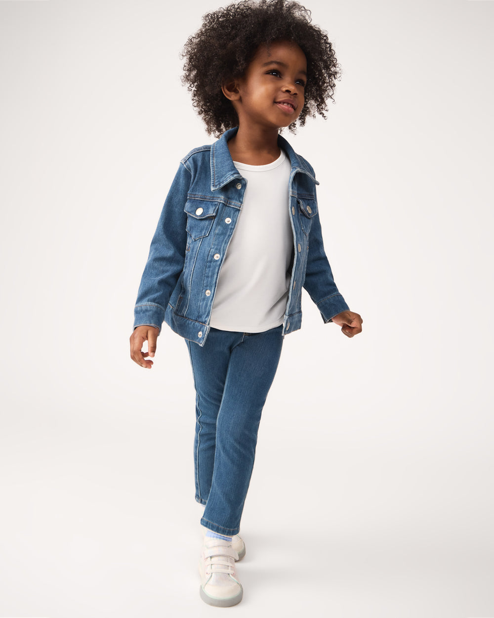 Girl wearing the Midwash Blue Denim Jegging with a white tee and jean jacket