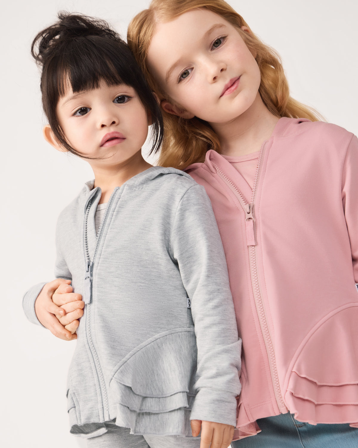 Two girls wearing matching Peplum Zip Hoodies