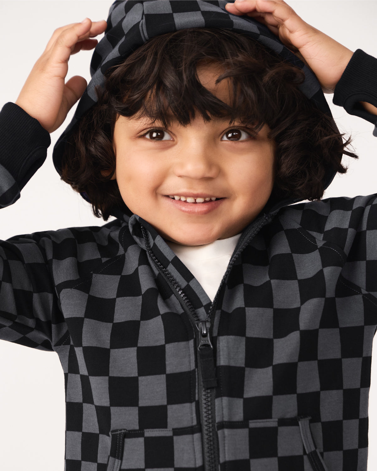 Boy wearing the Monochrome Checks Zip Hoodie with the hood on