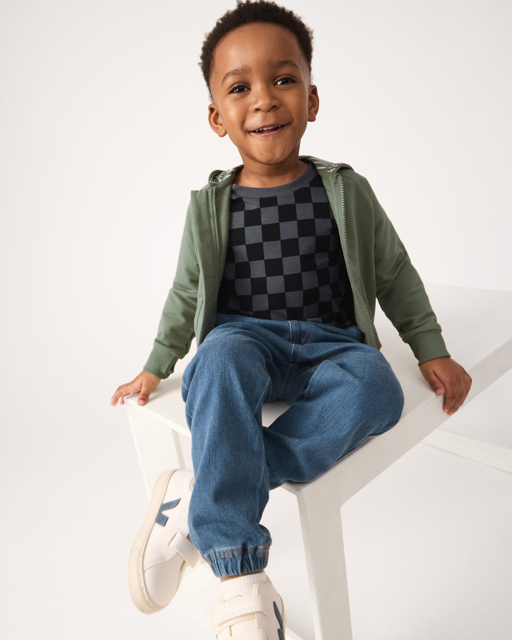 Boy wearing denim joggers and a checker print tee