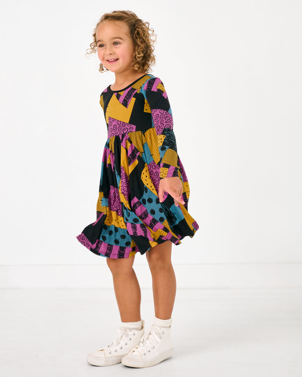 Standing girl wearing the Disney Sally's Patchwork Twirl Dress