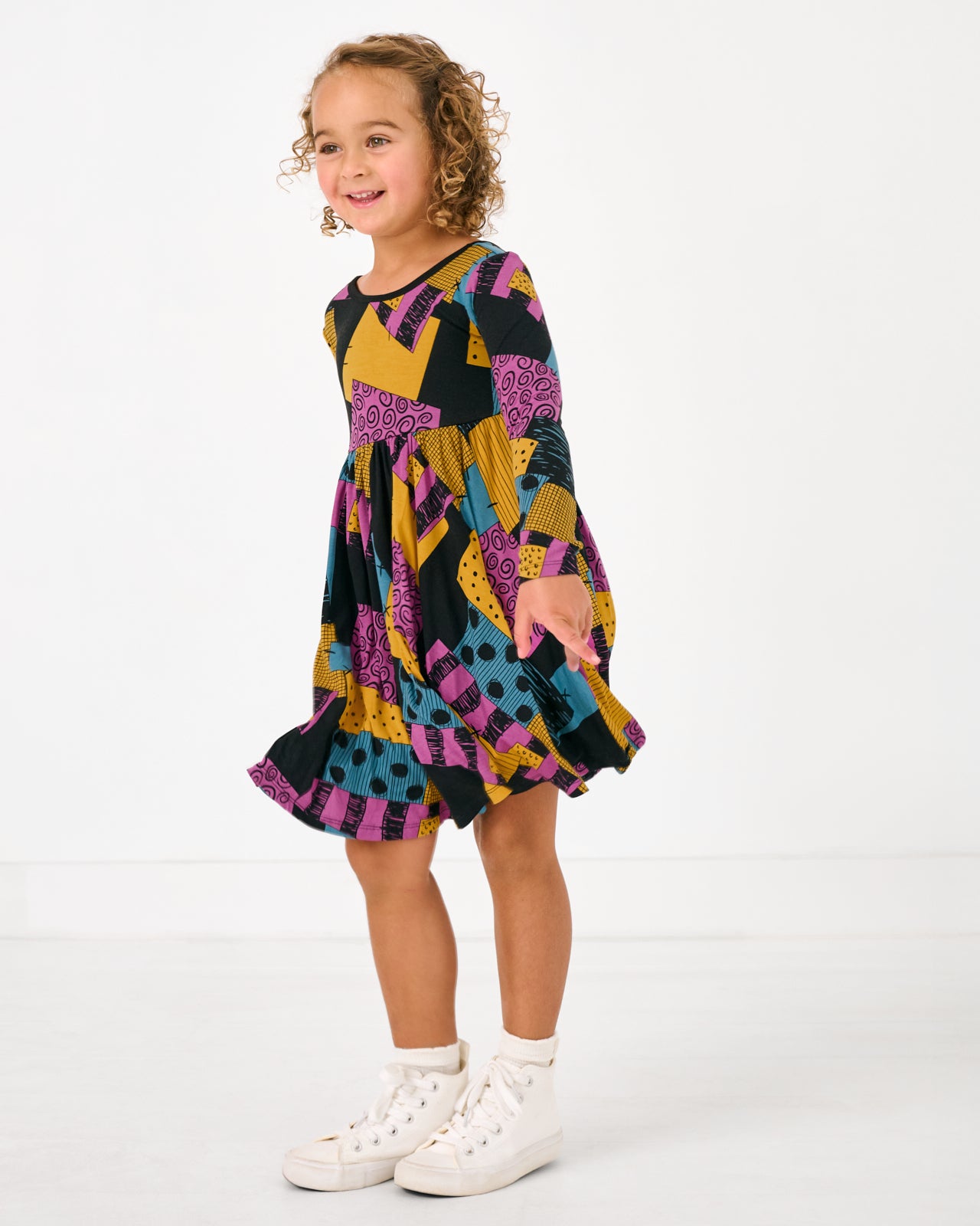 Standing girl wearing the Disney Sally's Patchwork Twirl Dress