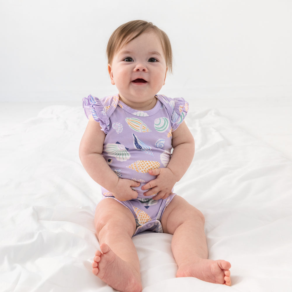Sitting child wearing the Sandy Treasures Flutter Bodysuit