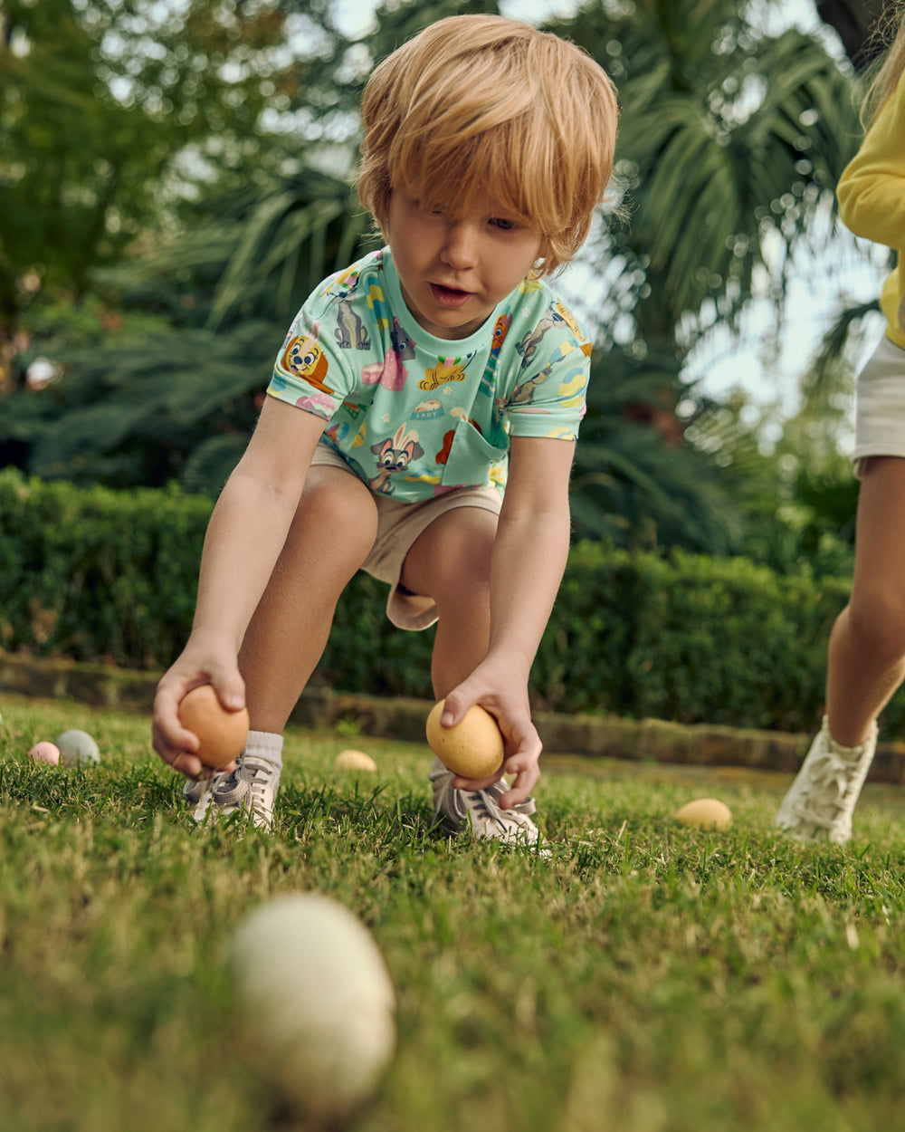Child playing with Easter eggs in the Disney Peekaboo Pets Relaxed Pocket Tee