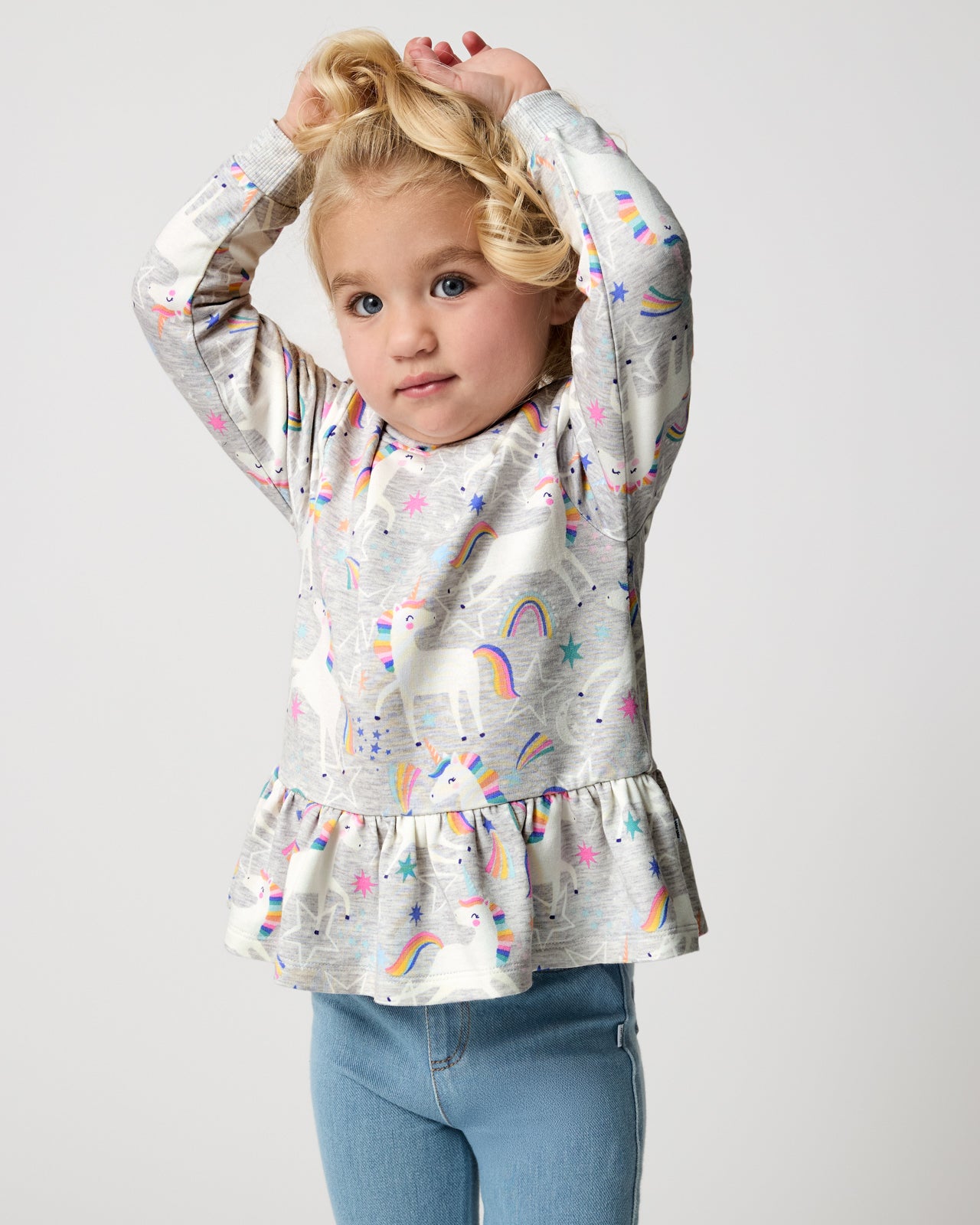 Girl wearing the Unicorn Dance Peplum Hooded Tee on a white background