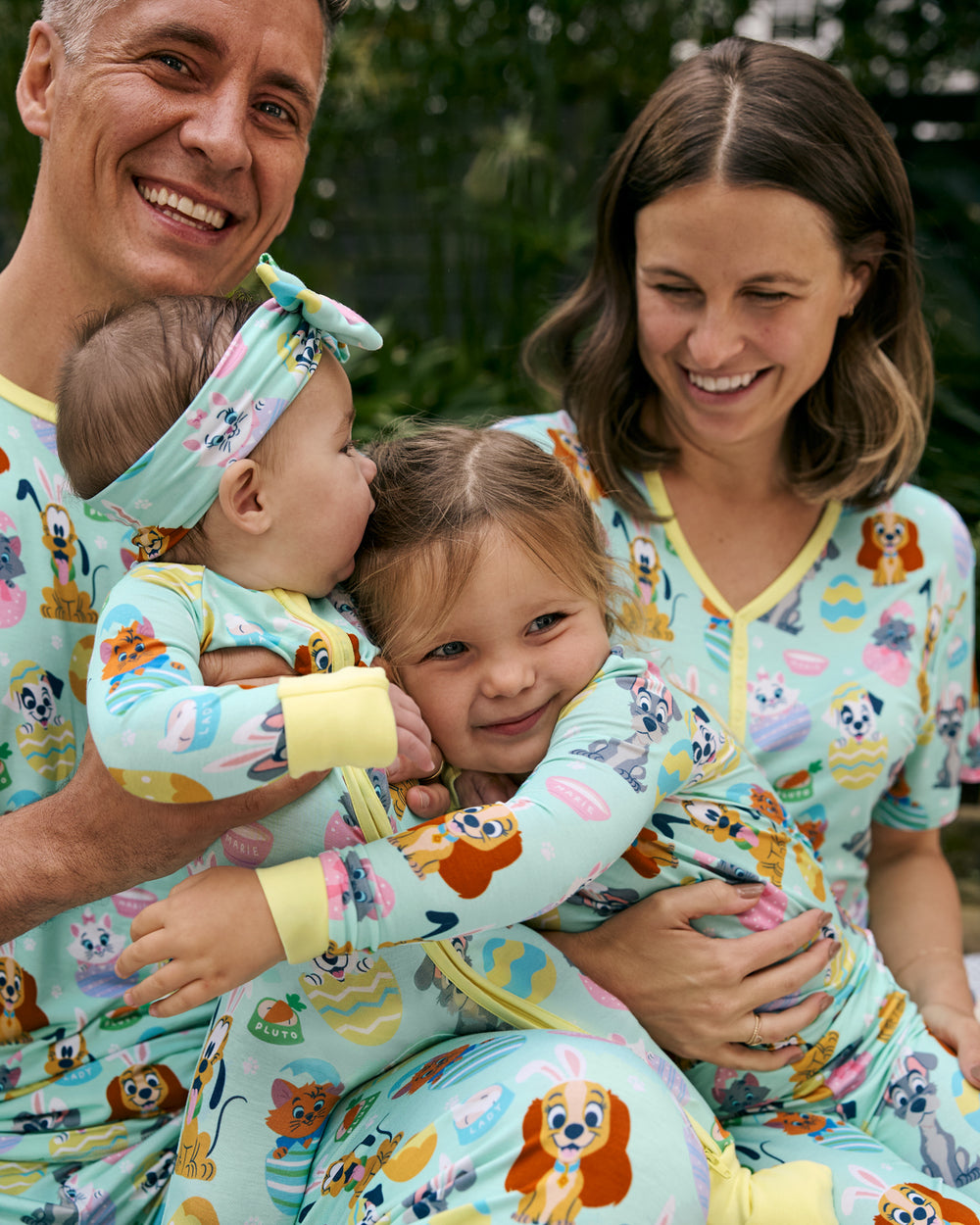 Family of four wearing matching Disney Peekaboo Pets Easter Pajamas