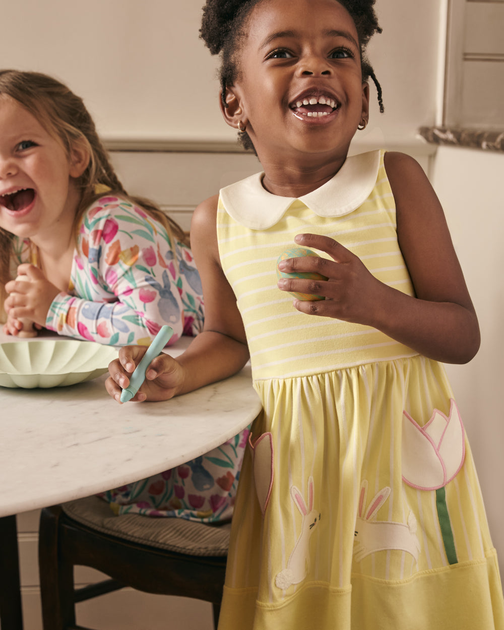Girl decorating Easter eggs in the Sunny Tulip Collar Skater Dress