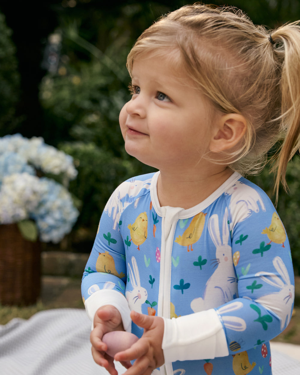 Girl wearing the Bunny Patch Zippy holding an Easter egg