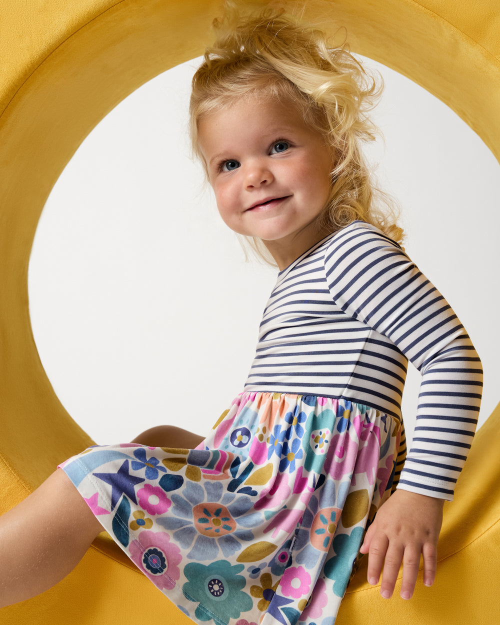 Girl wearing the Unicorn Blossoms Twirl Dress with Bodysuit on a yellow background