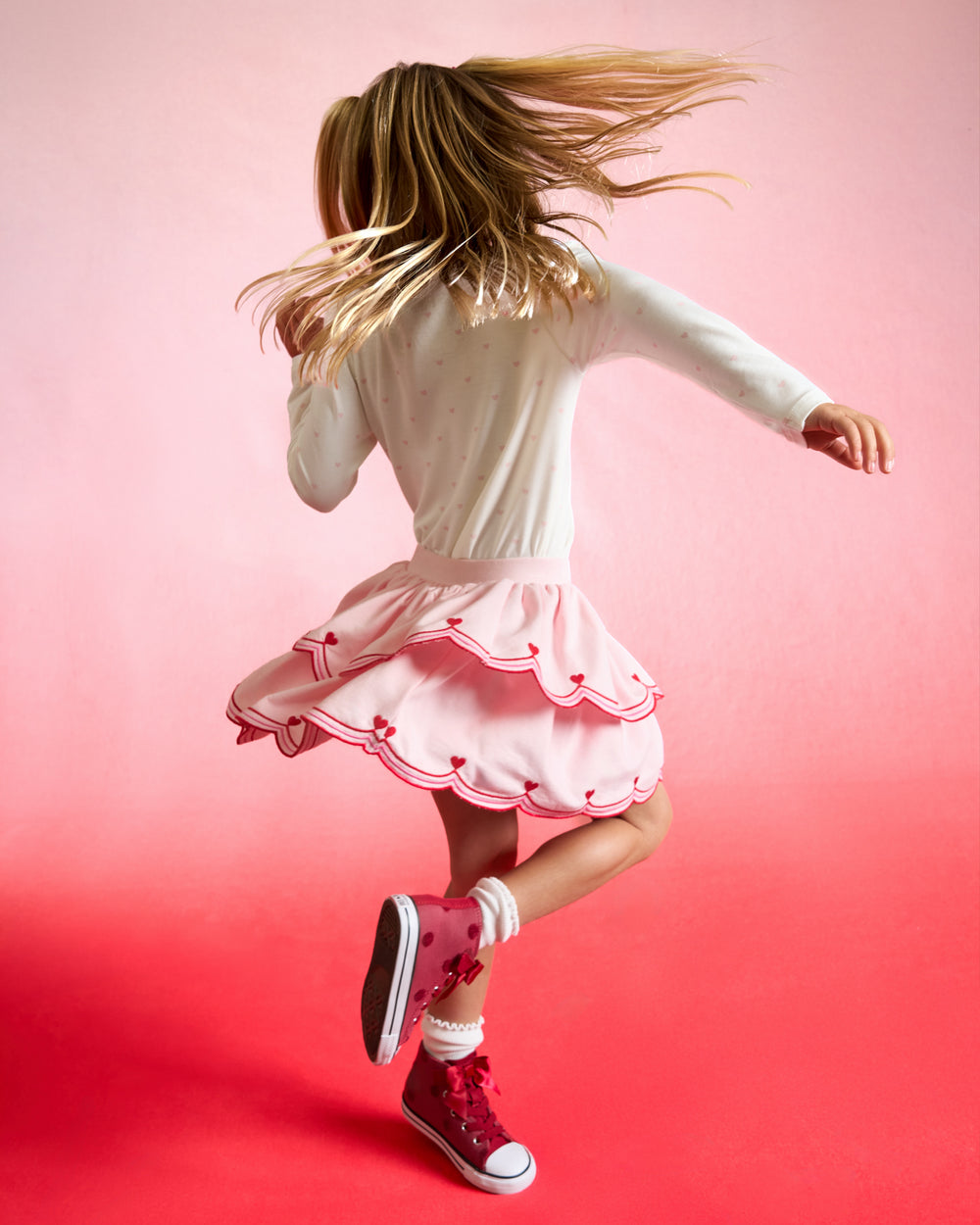 Twirling girl wearing the Prima Pink Scalloped Skort