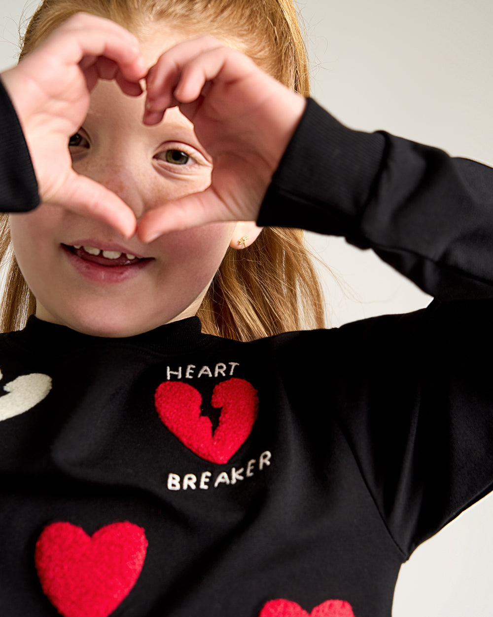 Posing girl wearing the Rebel Hearts Crewneck Sweatshirt