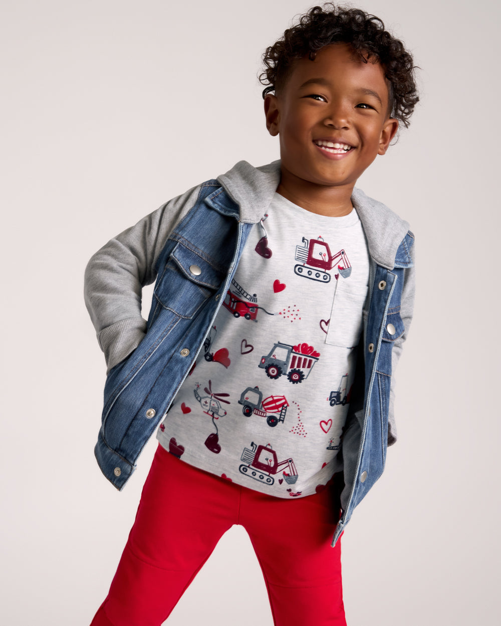 Boy wearing the Loads of Love Relaxed Pocket Tee layered under a trucker jacket