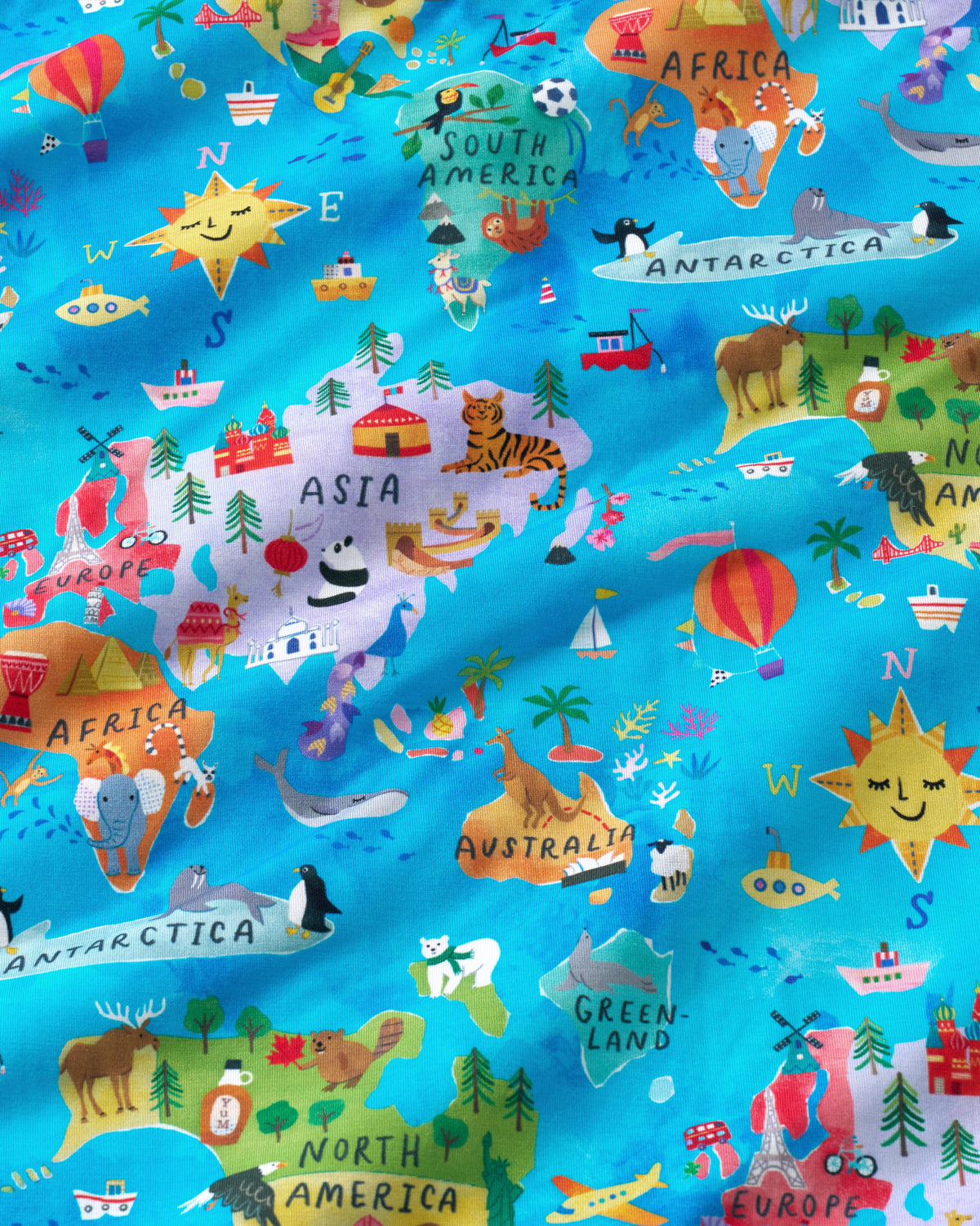 A close-up of a colorful illustrated fabric pattern showing world maps with animals, planets, ships, stars, and landmarks on a bright turquoise background.