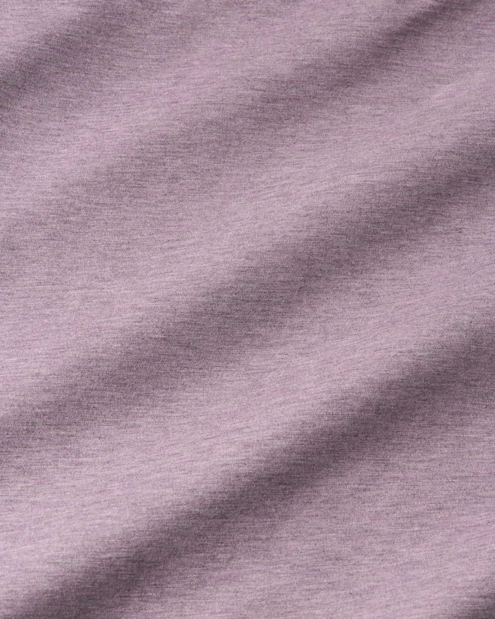 A close-up of a soft heathered fabric in a muted dusty lavender or mauve color, showing the texture and folds.