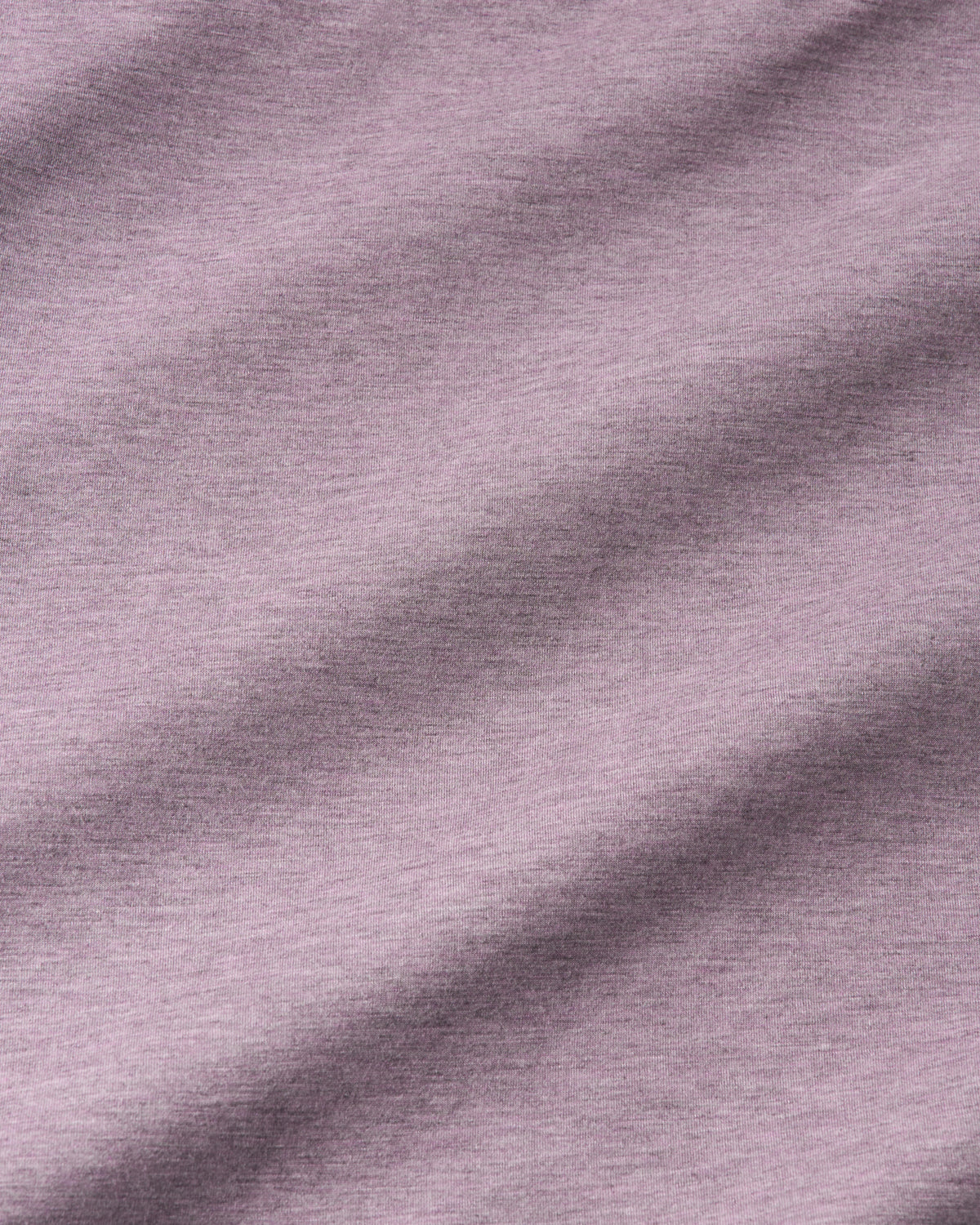 A close-up of a soft heathered fabric in a muted dusty lavender or mauve color, showing the texture and folds.
