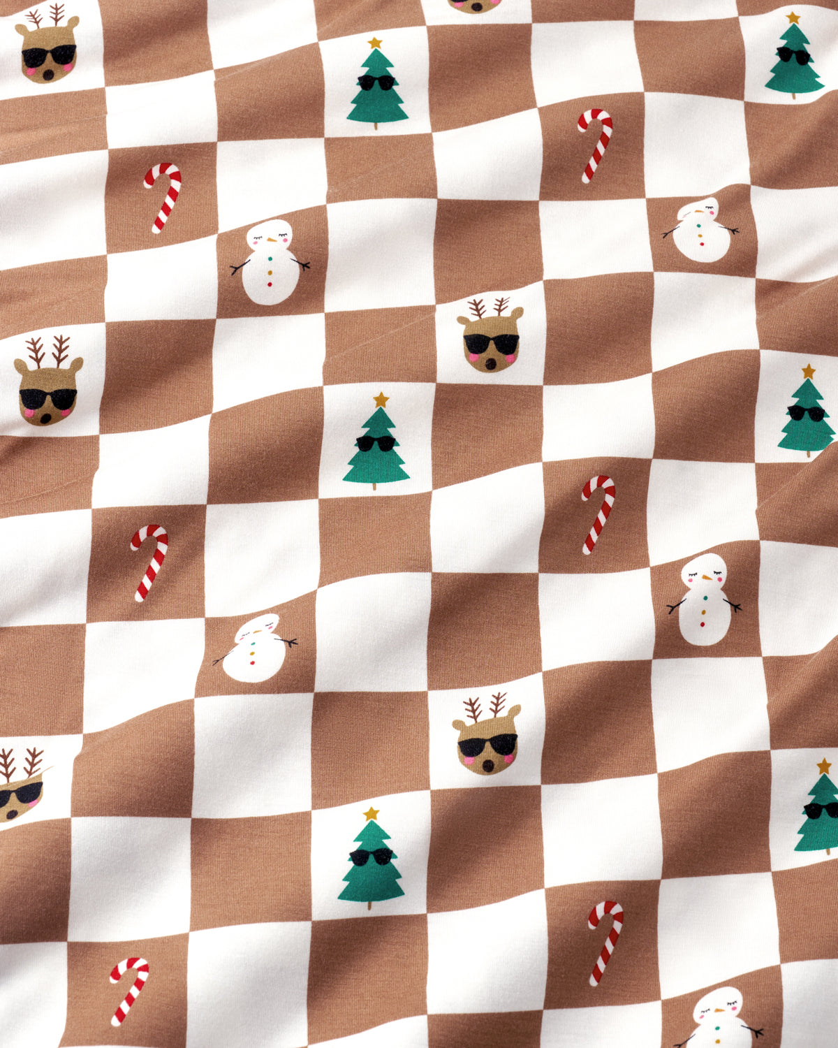 Brown and white checkered fabric with a Christmas theme, featuring small illustrations of candy canes, snowmen, Christmas trees, reindeer, and a Santa face.