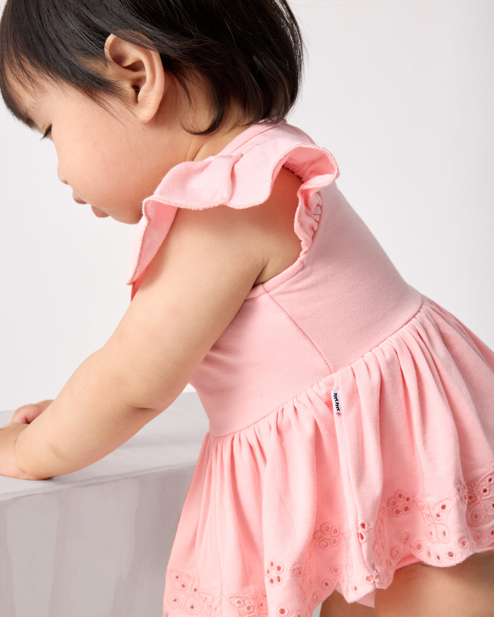 Close up of the eyelet details on the Soft Coral Puff Sleeve Eyelet Bodysuit