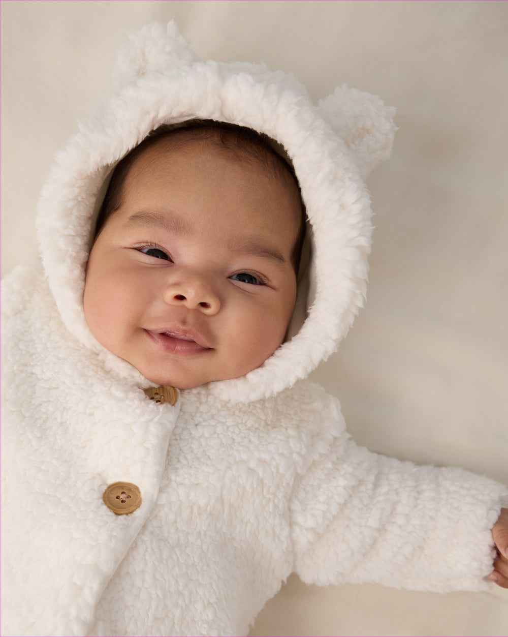 Close up of newborn wearing the Soft White Sherpa Baby Jacket