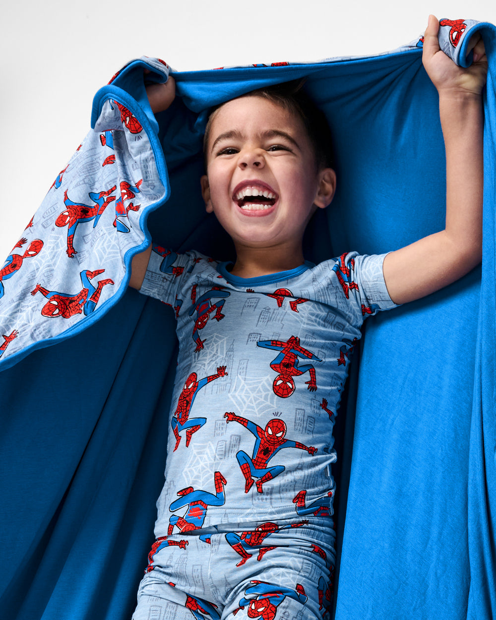 Boy holding up the Spidey Sense Large Cloud Blanket®