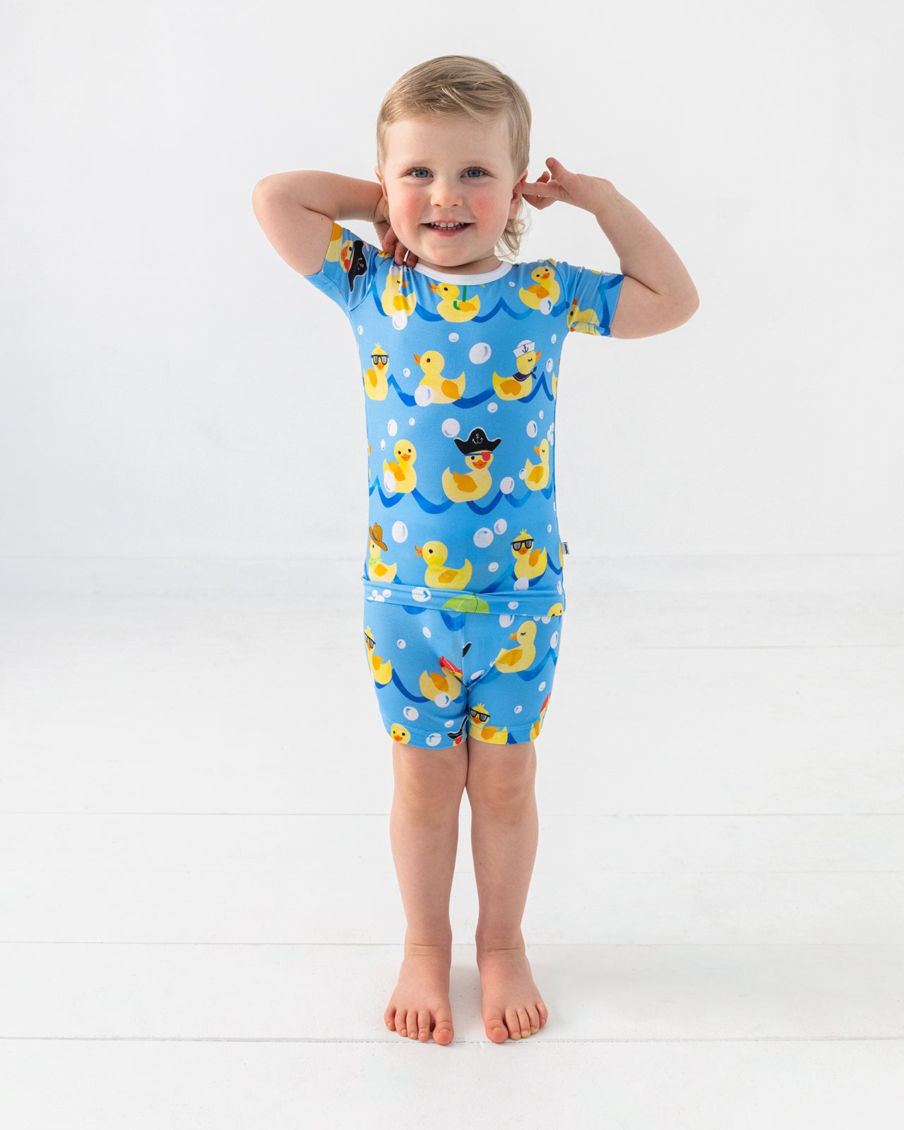 Standing boy wearing the Splish Splash Two-Piece Short Sleeve & Shorts Bamboo Pajama Set