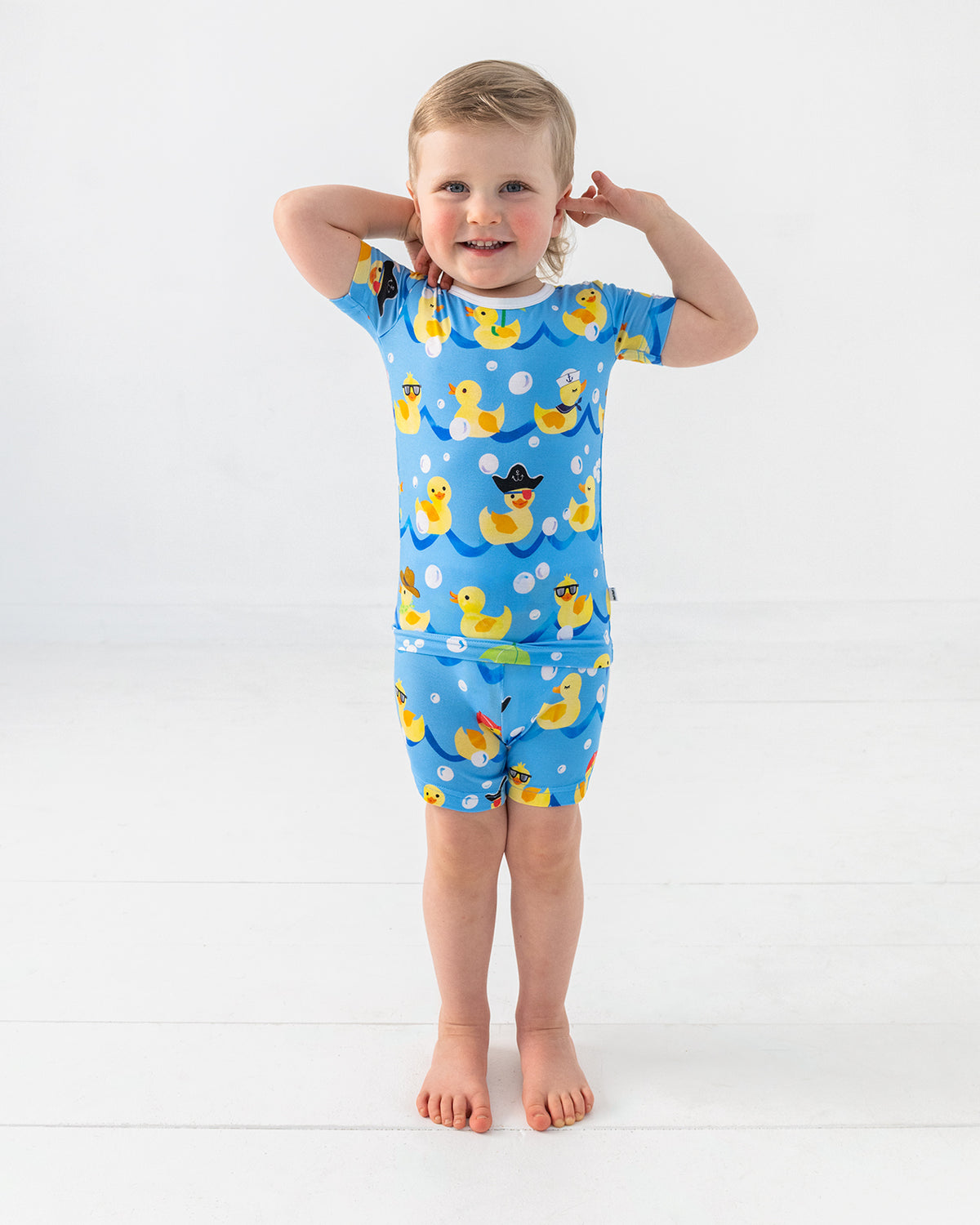 Standing boy wearing the Splish Splash Two-Piece Short Sleeve & Shorts Bamboo Pajama Set
