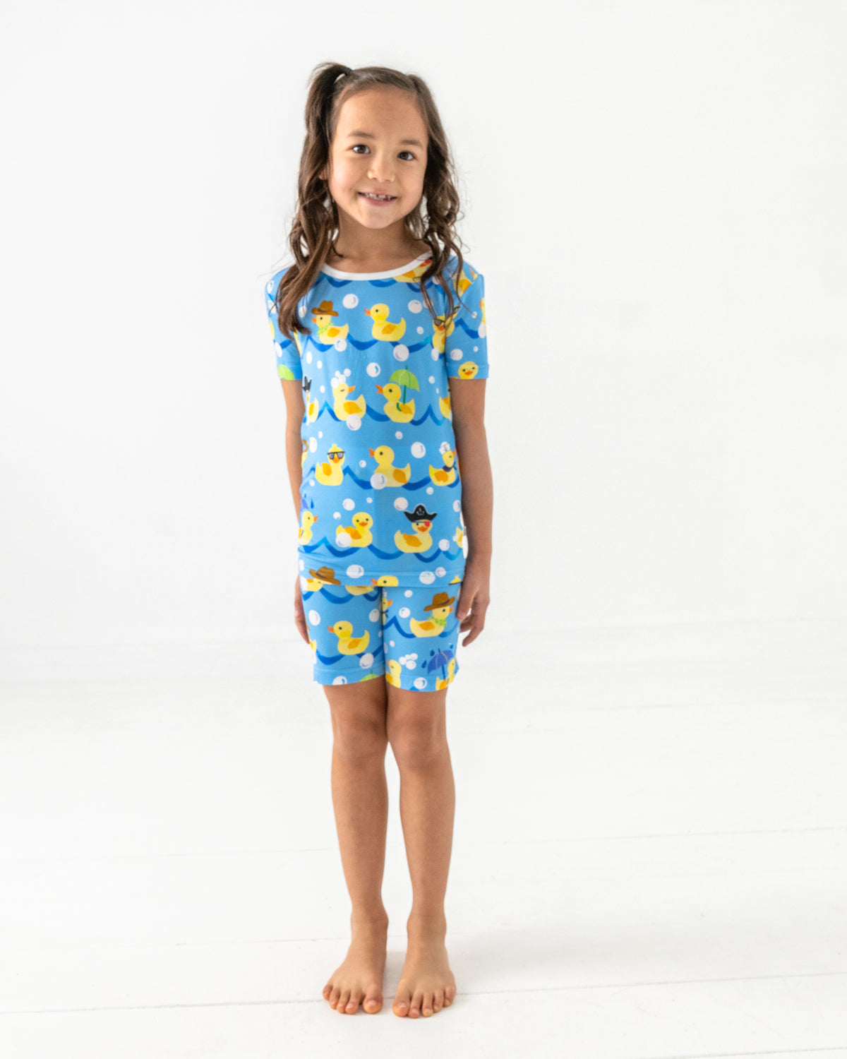 Standing girl wearing the Splish Splash Two-Piece Short Sleeve & Shorts Pajama Set