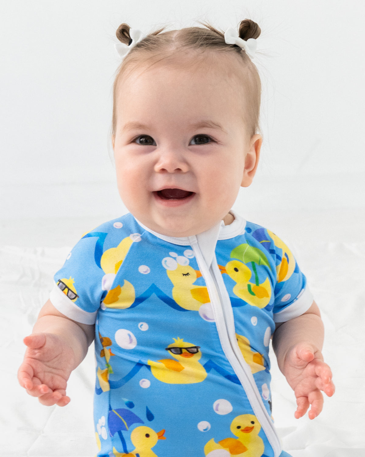 Close up of sitting baby wearing the Splish Splash Shorty Zippy