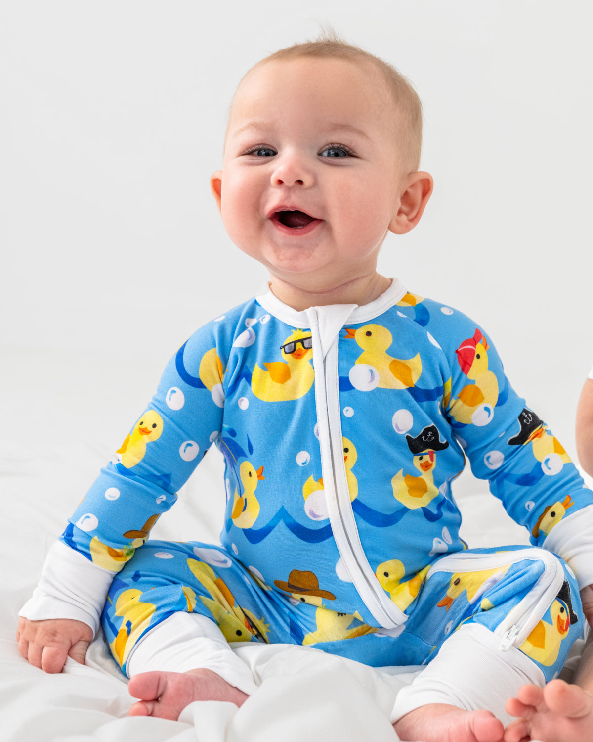 Sitting baby wearing the Splish Splash Zippy