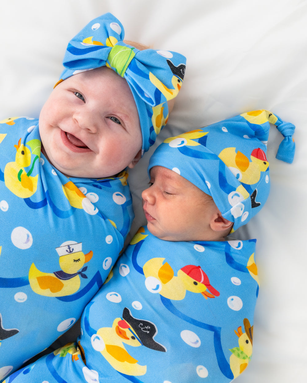 Two babies wearing Splish Splash Swaddle Sets
