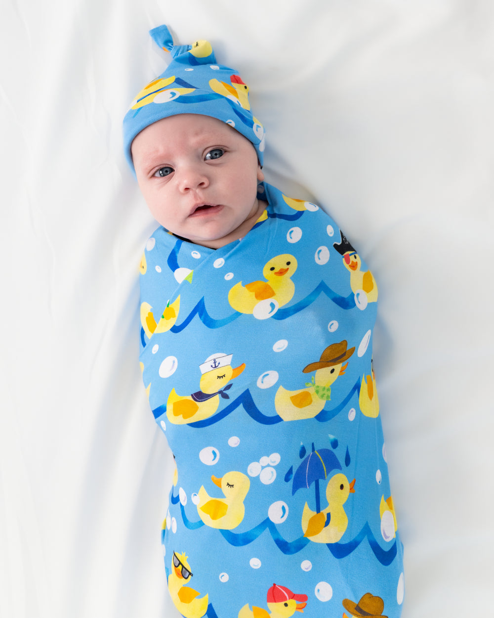 Aerial view of baby wearing the Splish Splash Swaddle & Hat Set