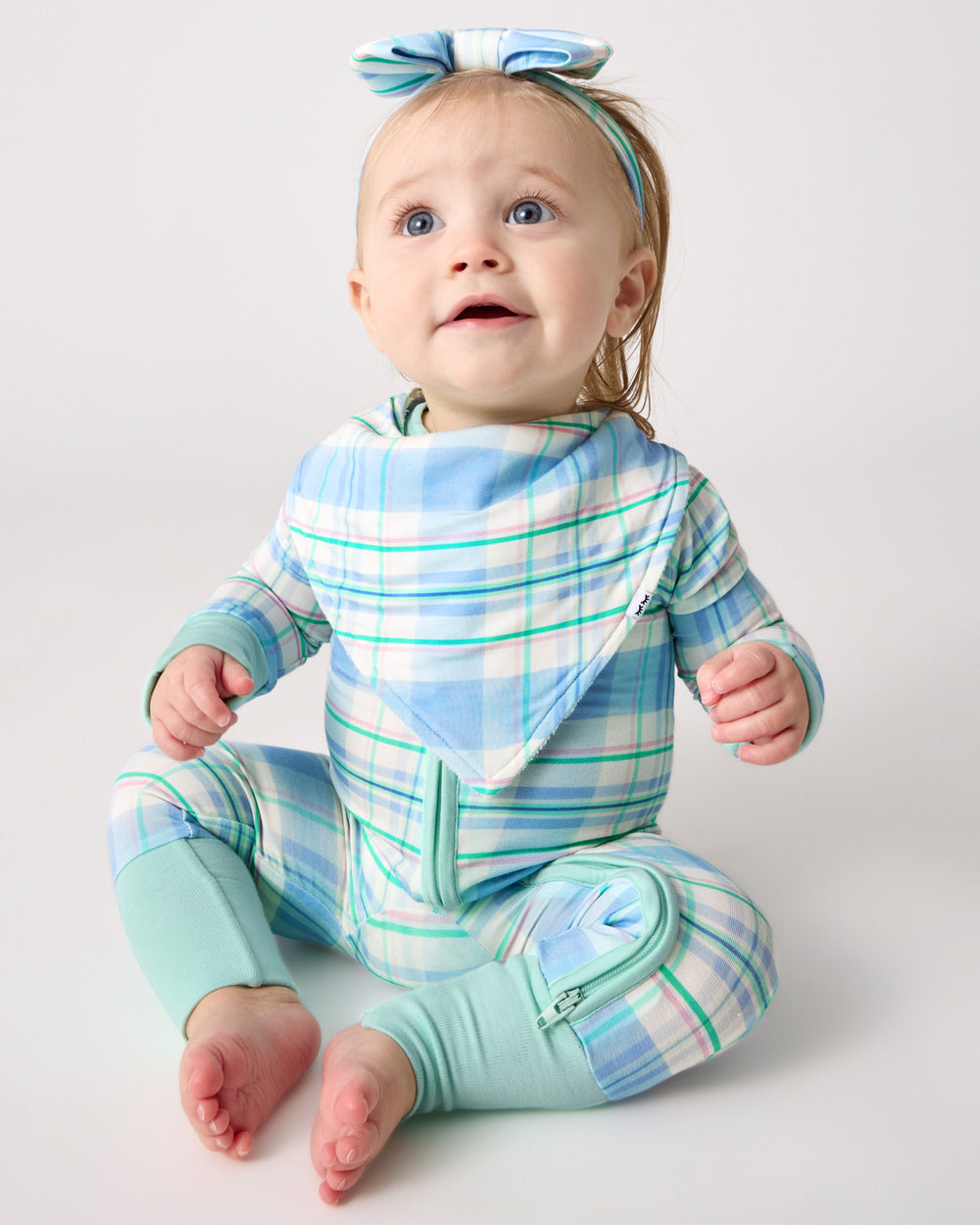 Sitting baby wearing the Springtime Plaid Bandana Bib and Zippy