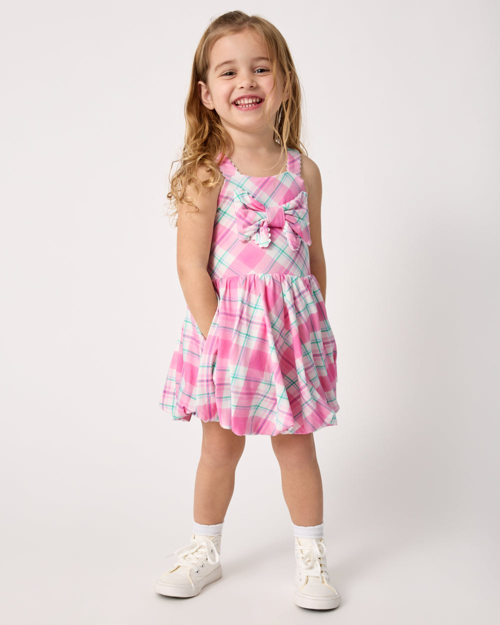 Girl wearing the Springtime Plaid Bow Bubble Dress with white sneakers