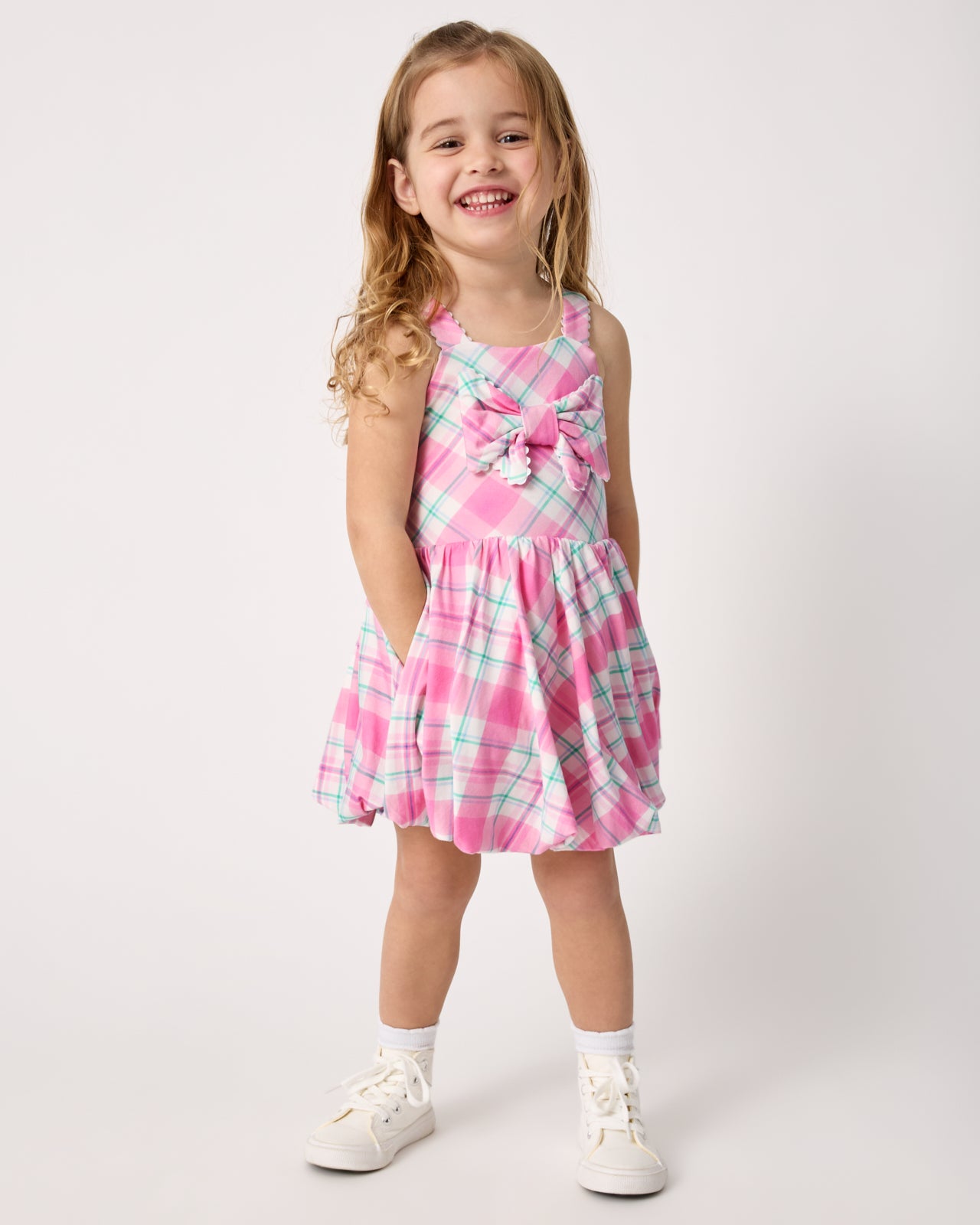 Girl wearing the Springtime Plaid Bow Bubble Dress with white sneakers