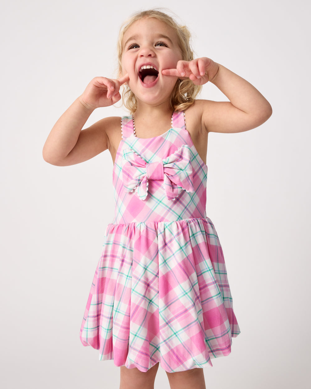 Posing girl wearing the Springtime Plaid Bow Bubble Dress