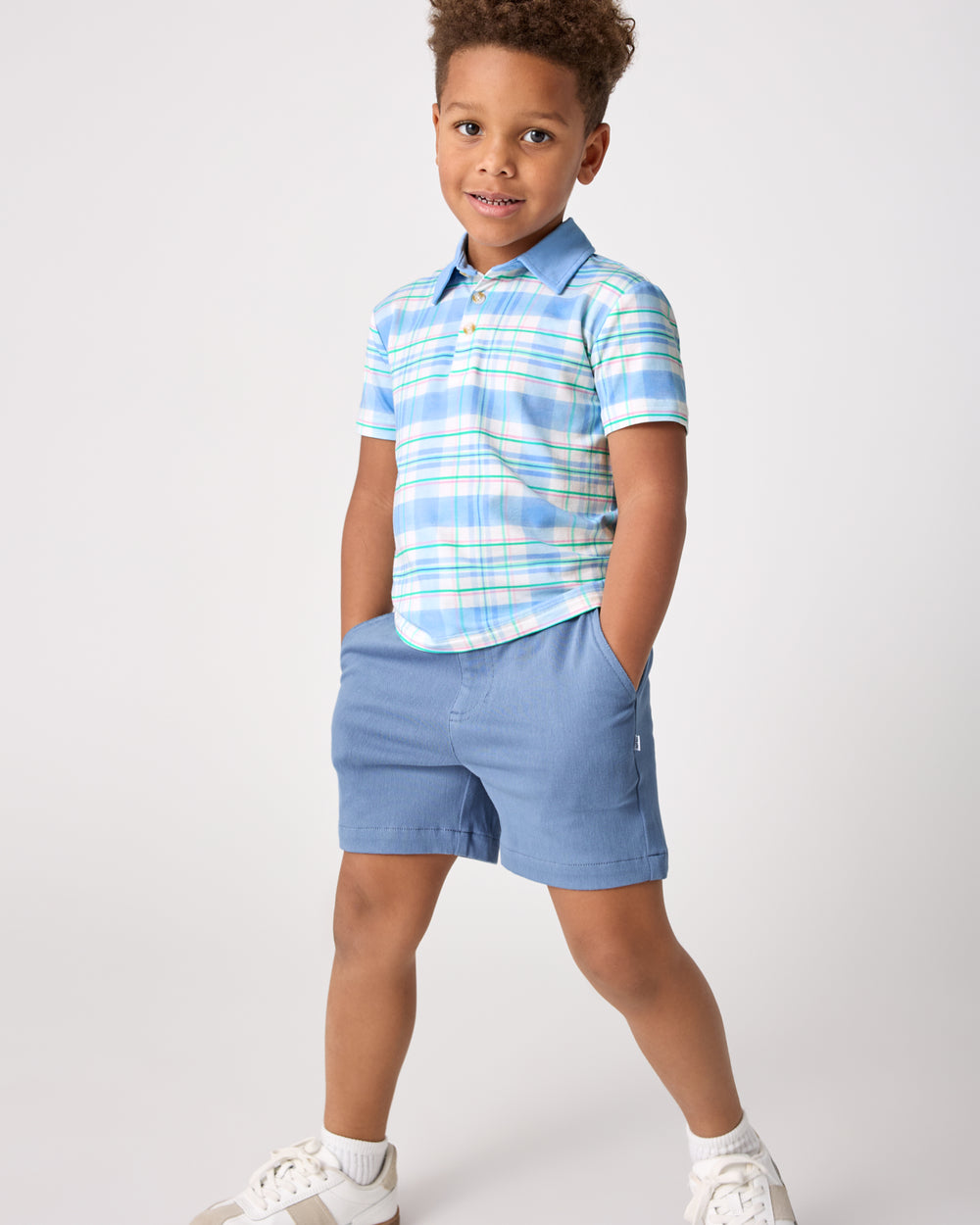 Child wearing the Springtime Plaid Polo Shirt with blue chino shorts