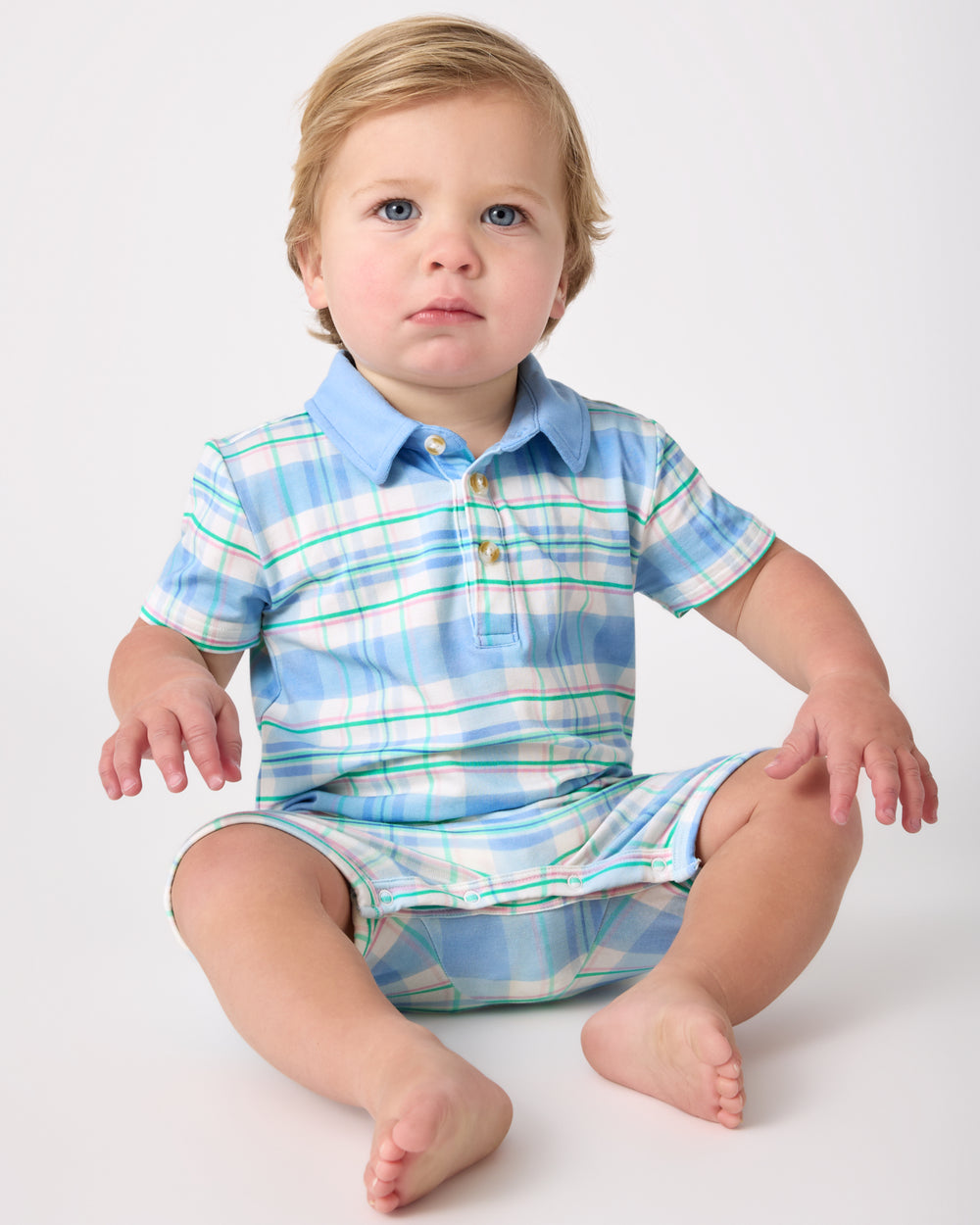 Sitting child wearing the Springtime Plaid Polo Shorty Romper
