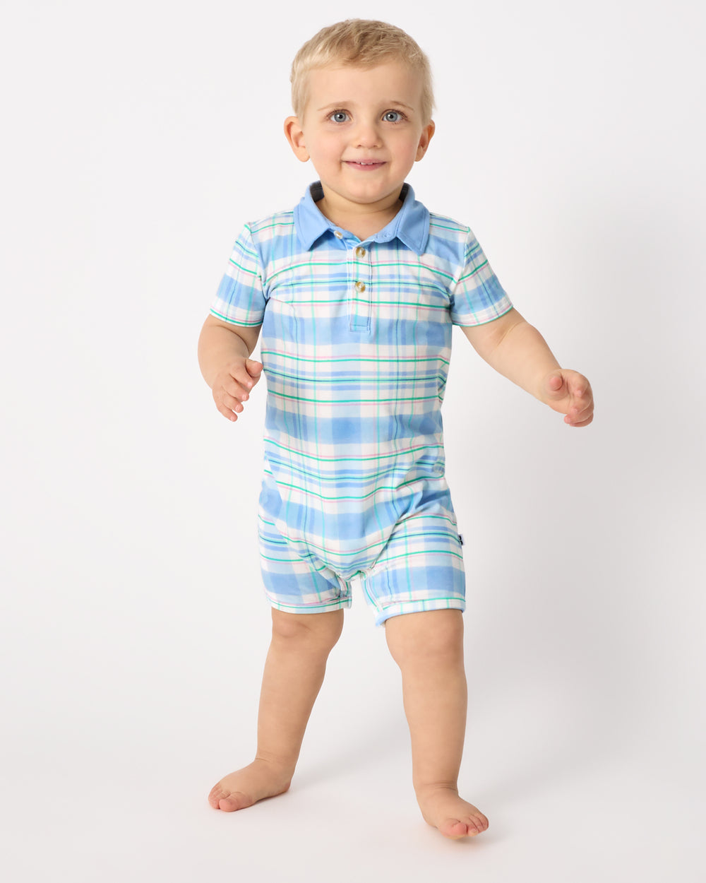 Walking boy wearing the Springtime Plaid Polo Shorty Romper