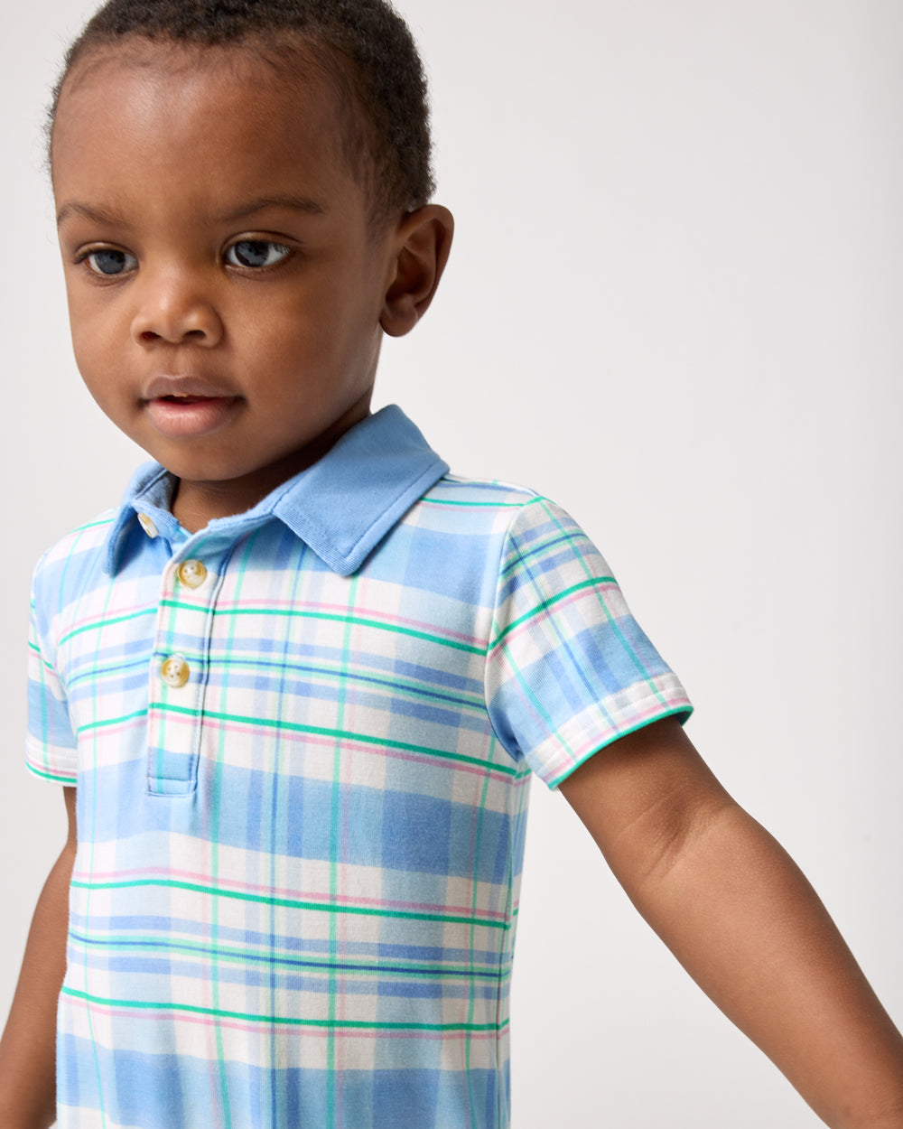 Close up of child wearing the Springtime Plaid Polo Shorty Romper