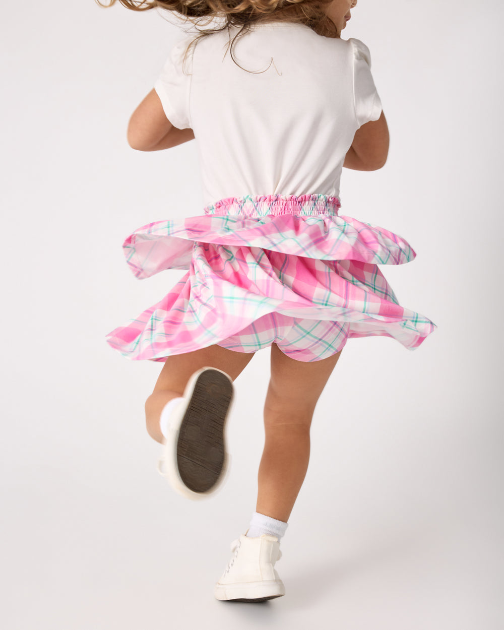 Alternate of child in motion wearing the Springtime Plaid Tiered Skort with a white tee