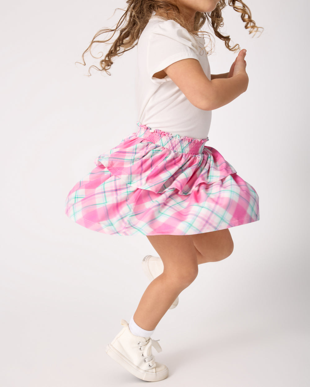 Child in motion wearing the Springtime Plaid Tiered Skort