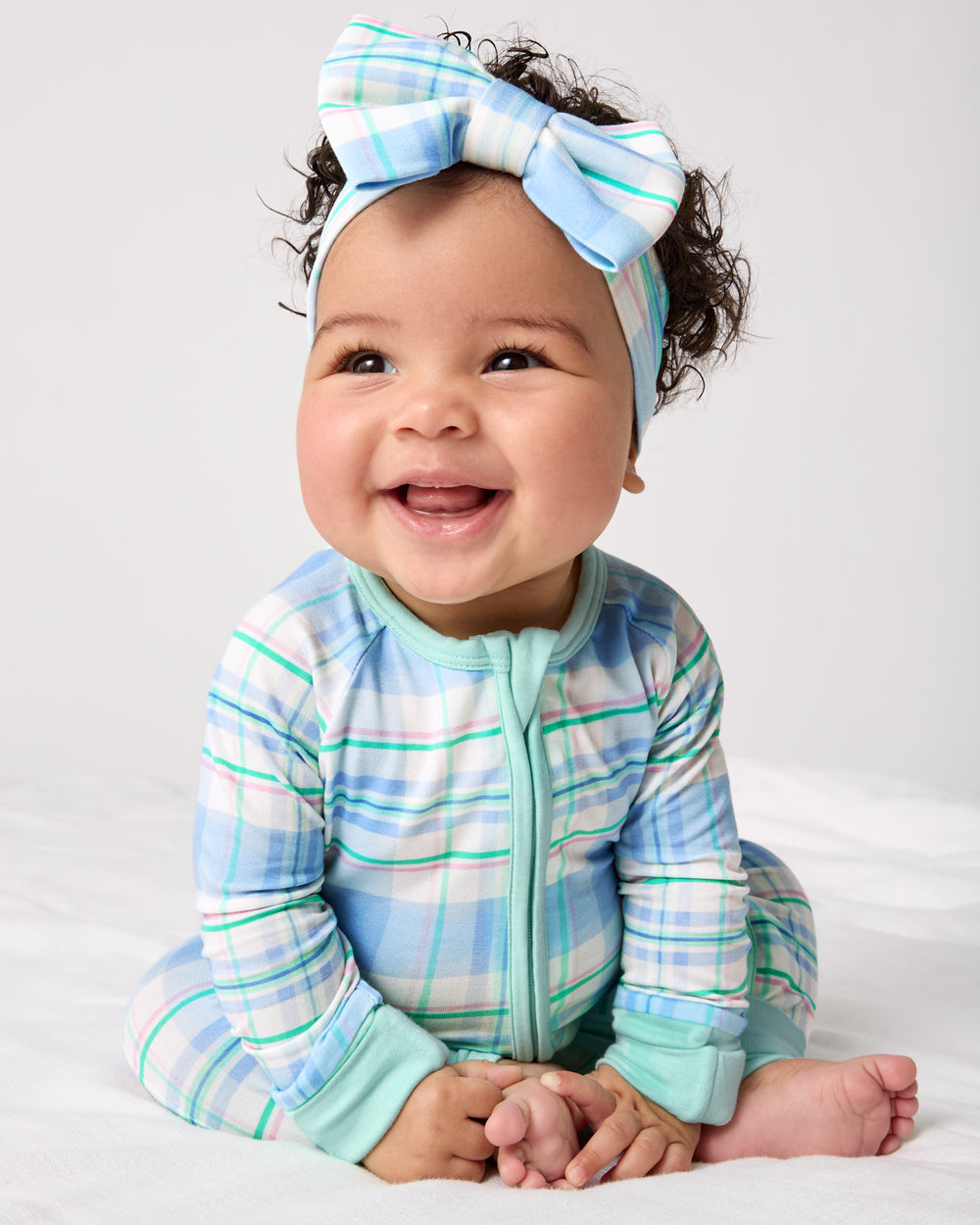 Baby wearing the Springtime Plaid Zippy and Luxe Bow Headband
