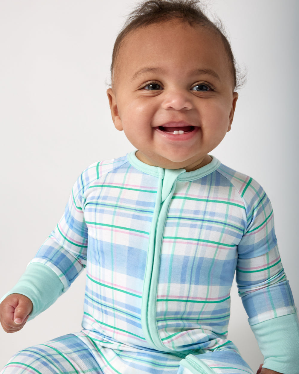 Close up of baby wearing the Springtime Plaid Zippy