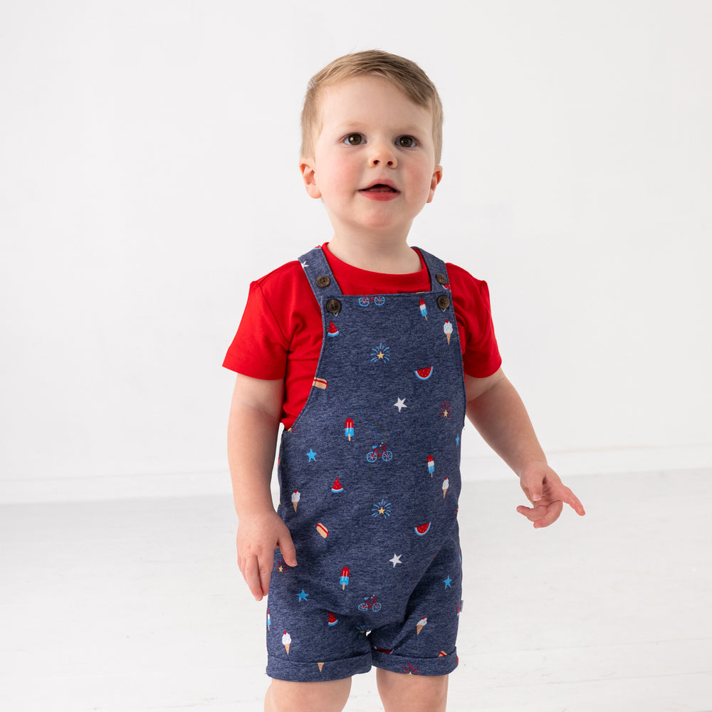 Standing child wearing the Summer Celebrations Shorty Overall