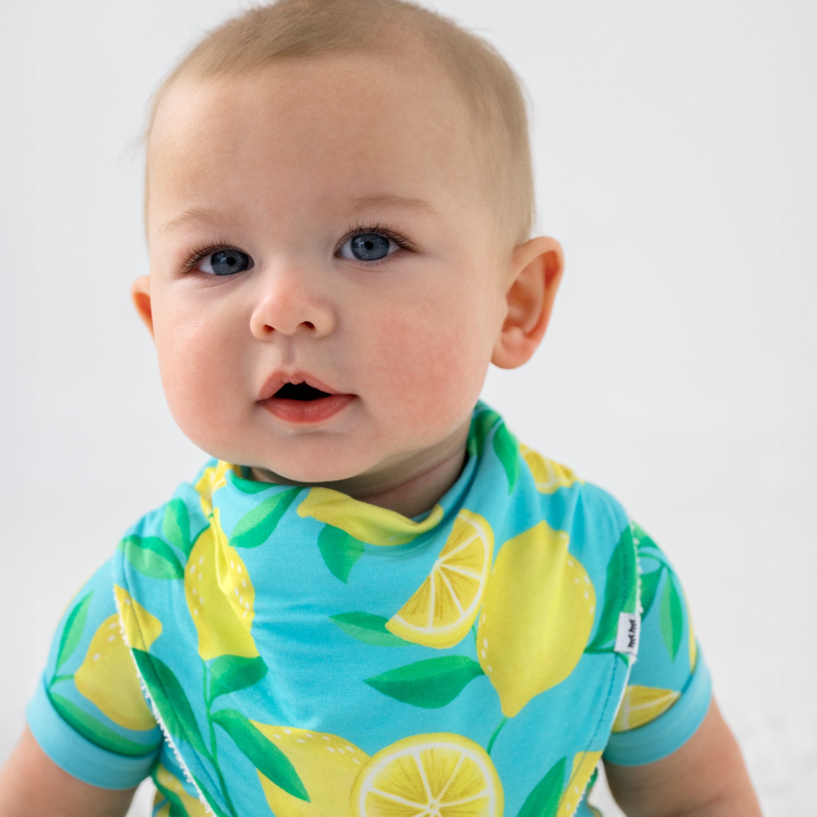 Close up of child wearing the Blue Sunny Citrus Bandana Bib
