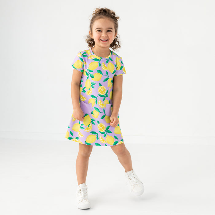 Standing child wearing the Lavender Sunny Citrus A-Line Pocket Dress
