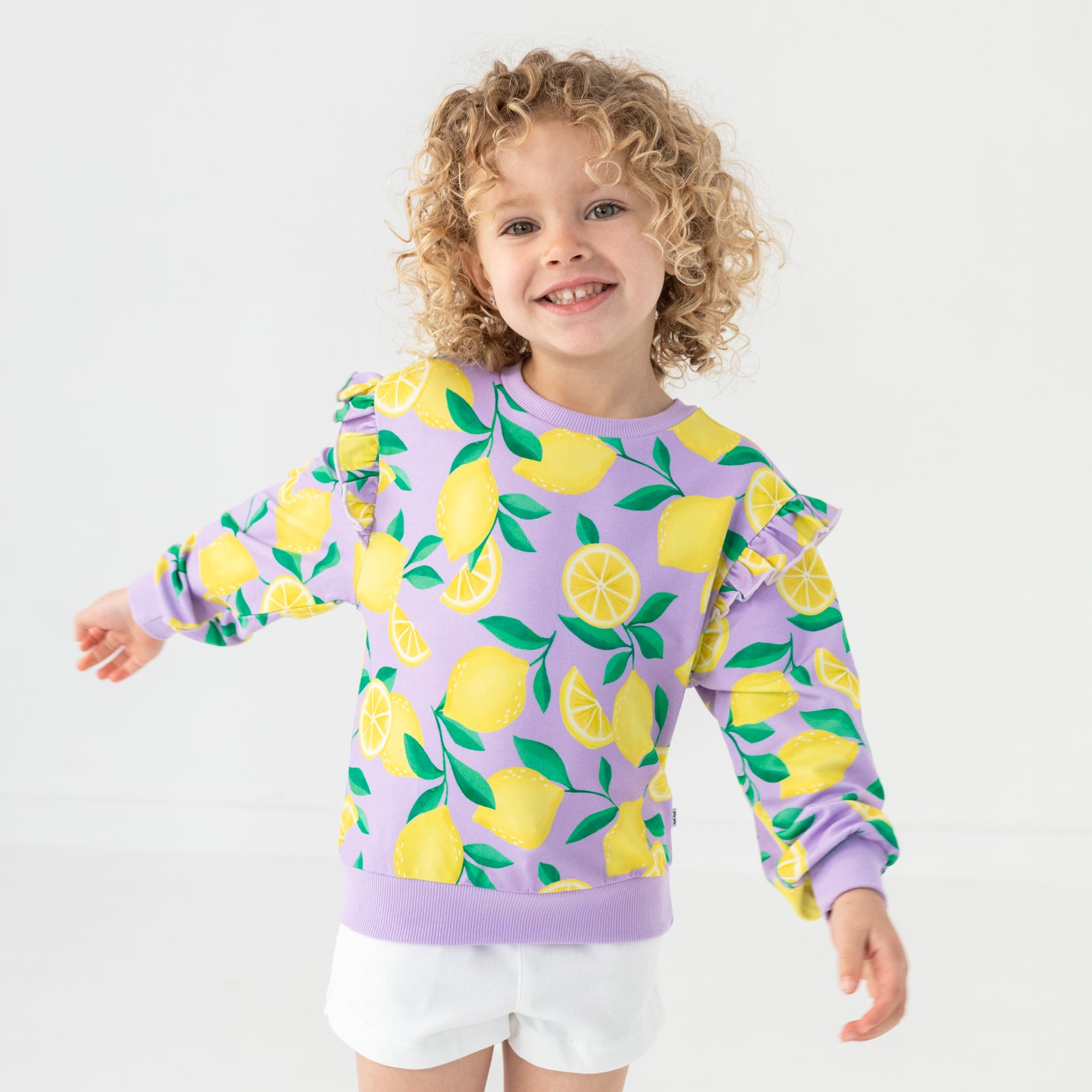 Standing child wearing the Lavender Sunny Citrus Flutter Crewneck