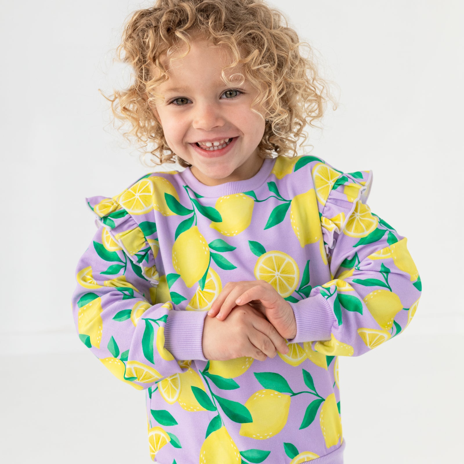 Close up of child wearing the Lavender Sunny Citrus Flutter Crewneck