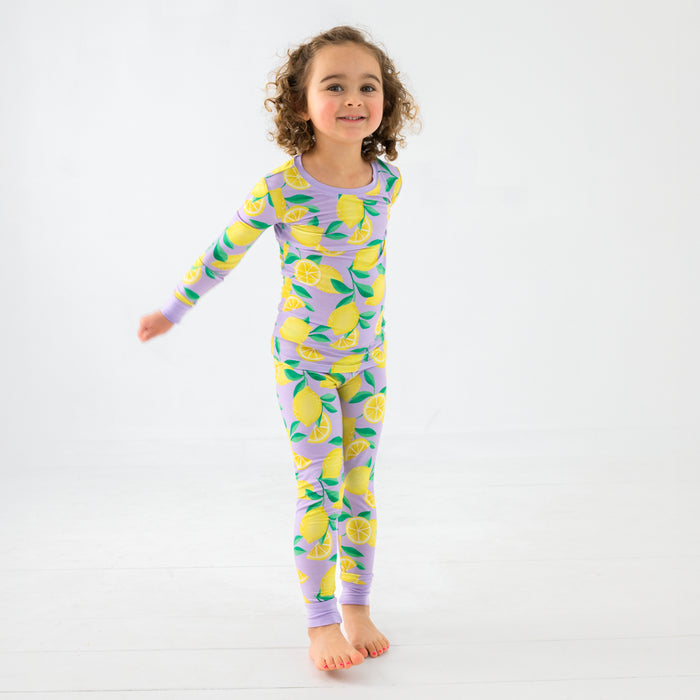 Standing chilld wearing the Lavender Sunny Citrus Two-Piece Pajama Set